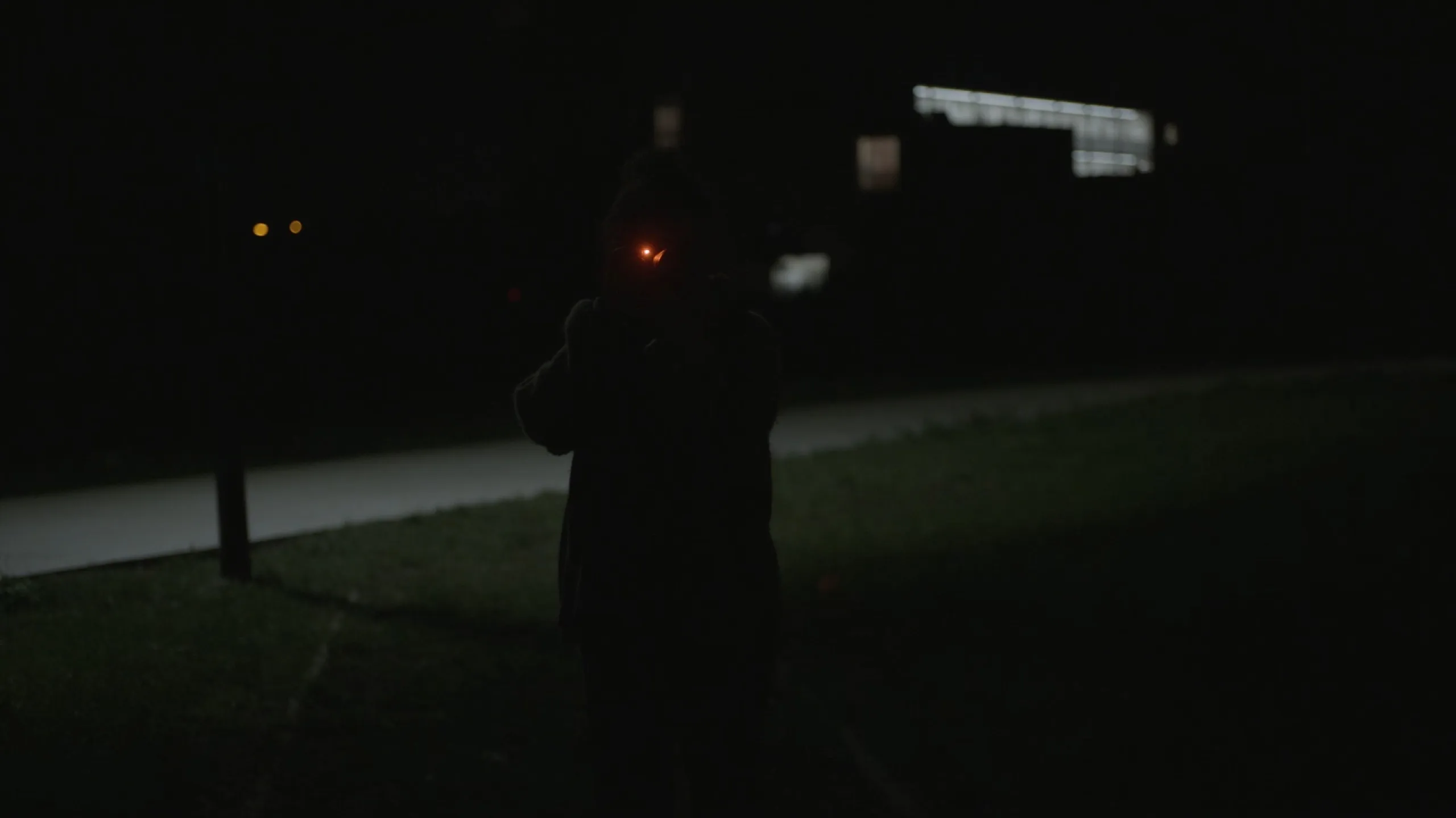 Chance Encounters: dark silhouette of a photographer at night, camera focus light glowing red
