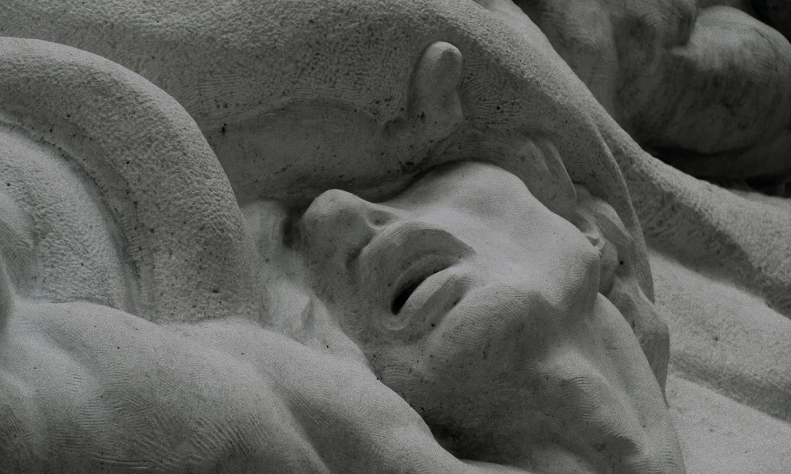 Les Homards Immortels: carved marble face with parted lips emerging from folds of sculpted stone