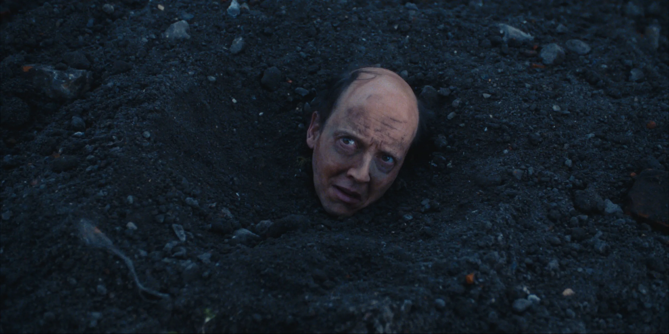 Bearer of Bad News: Svens head sticks out of black earth as he looks up in fear